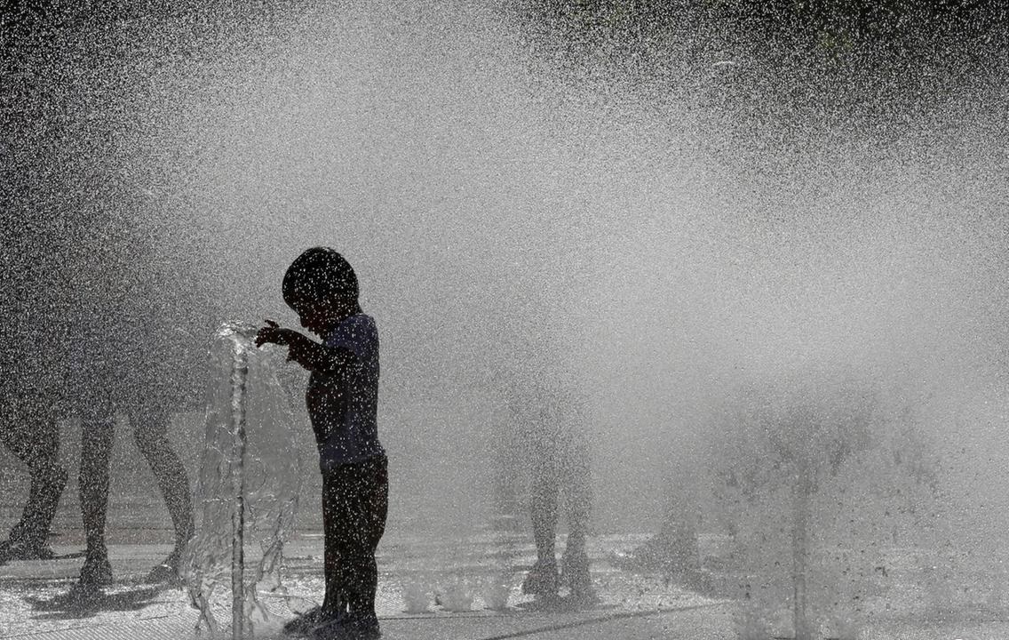 خنک شدن مردم با آب فواره‌ها در پامپلونای اسپانیا