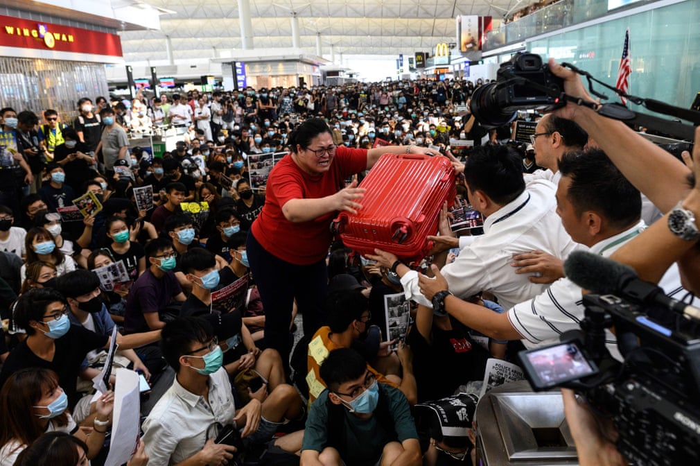 تلاش یک مسافر در فرودگاه هنگ‌کنگ برای رساندن چمدانش از بین اعتصاب کنندگان