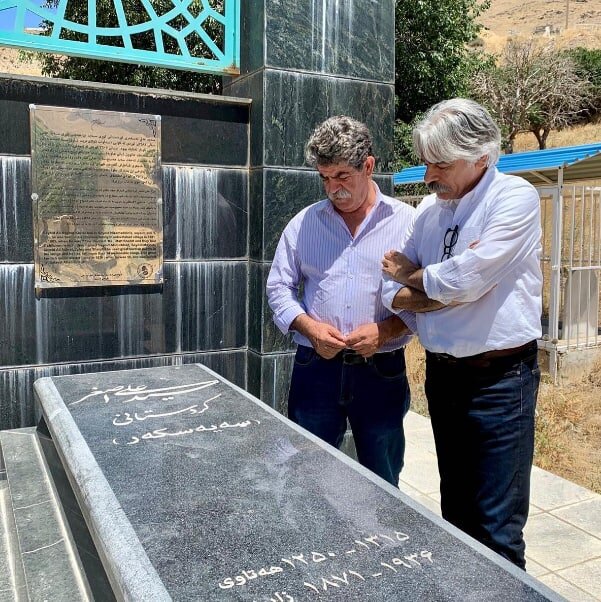 کیهان کلهر ایستاده بر آرامگاه سیدعلی‌اصغر کردستانی