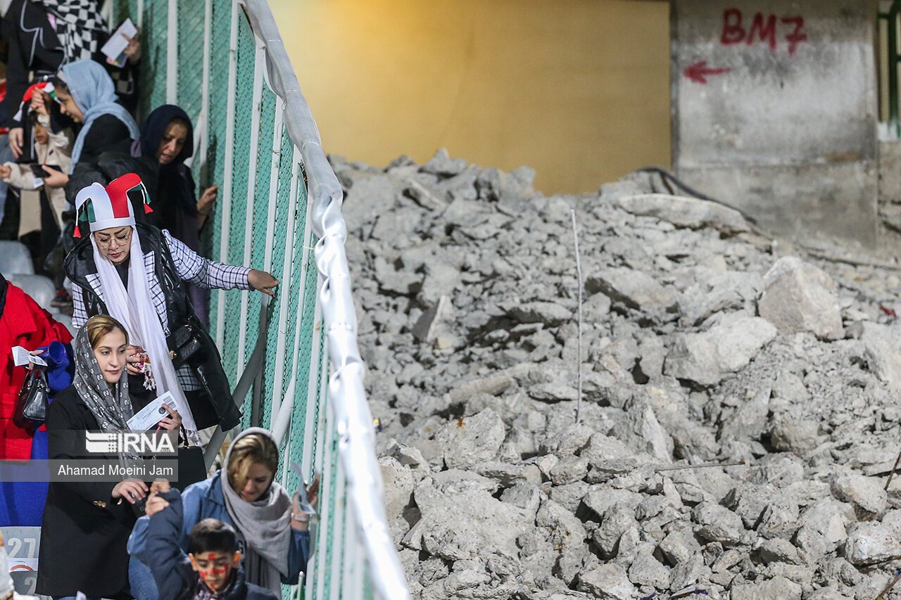 زنان تماشاگر در کنار سکوهای مخروبه ورزشگاه آزادی