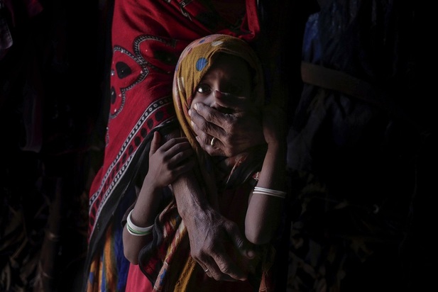 مادر یمنی که دهان کودکش را با دست گرفته تا او را ساکت کند. کودک 5 ساله روزی کمتر از 800 کالری از نان و برنج دریافت میکند که تقریبا کمتر از نیمی از کالری است که کودکان همسن او در جهان باید دریافت کنند.